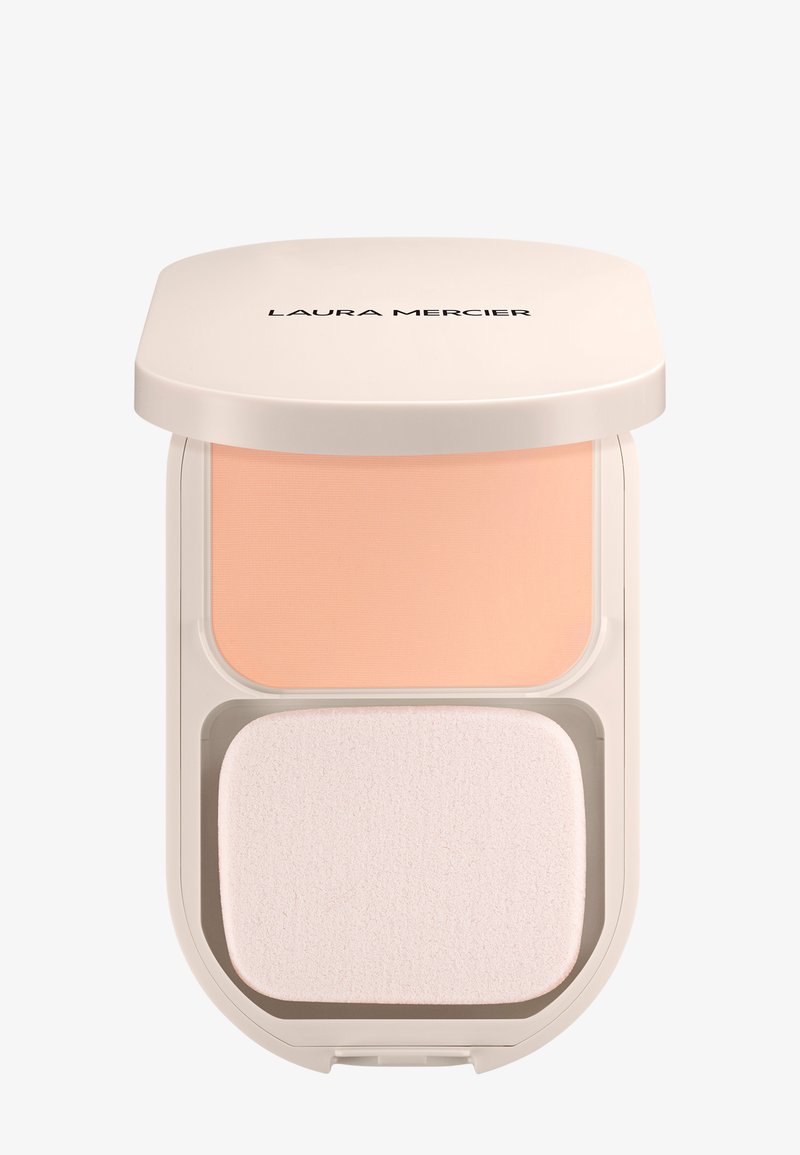 Base en polvo compacta beige con una esponja aplicadora blanca dentro de un estuche cuadrado de Laura Mercier en un tono beige claro y con bordes redondeados.