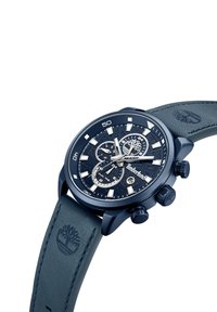 Orologio cronografo blu scuro con quadrante texturizzato, dettagli in argento e un cinturino in pelle abbinato con logo impresso. Presenta tre sottodial.