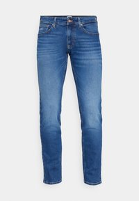 Vaqueros de denim azul ajustados con un diseño deslavado, que cuentan con bolsillos frontales, cierre de botón y sutilezas en los detalles de costura a lo largo de las costuras.