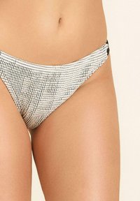 Majtki bikini w teksturowanym, czarno-białym wzorze, z niskim stanem i cienkimi bocznymi paskami dla minimalistycznego wyglądu.