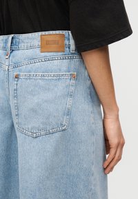 Jeans in denim azzurro chiaro con taglio dritto. Caratterizzati da cuciture a contrasto, una toppa in pelle del marchio in vita e due tasche posteriori.