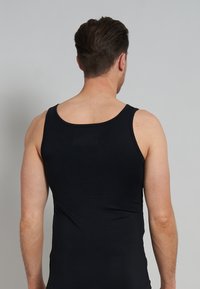Black tank top with a fitted design. Features wide straps, a rounded neckline, and smooth texture. Back view shows a classic cut and minimal seams.