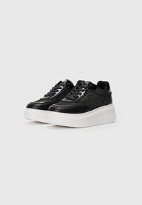 Sorte sneakers med glitrende stoff og glatte lærdetaljer. Tykk hvit såle, rund tå og snøring. Minimalistisk logo detalj.