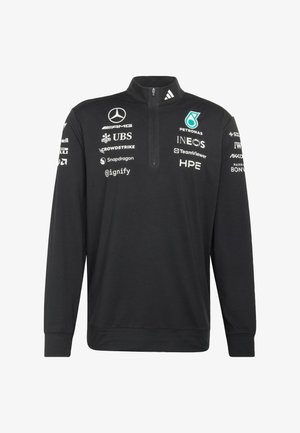 Pullover nero a maniche lunghe con collo a zip. Presenta loghi bianchi e colorati di diversi marchi sul davanti e sulle maniche.