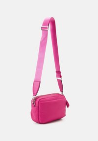 Różowa torba na ramię o gładkiej, wyściełanej fakturze, prostokątnym kształcie, regulowanym pasku i zamknięciu na zamek błyskawiczny dla łatwego dostępu.