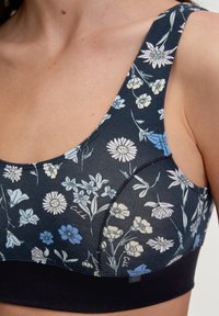 Bh met bloempatroon, voorzien van een donkerblauwe basis met lichtblauwe, crème en witte bloemen. Rekbare stof en brede banden, met een zwarte band.