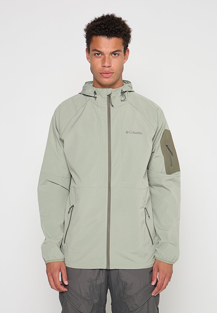 Chaqueta con capucha de color verde claro, con cremallera frontal, bolsillos laterales y puños elásticos. Presenta un acento en color verde oscuro que contrasta en la manga.