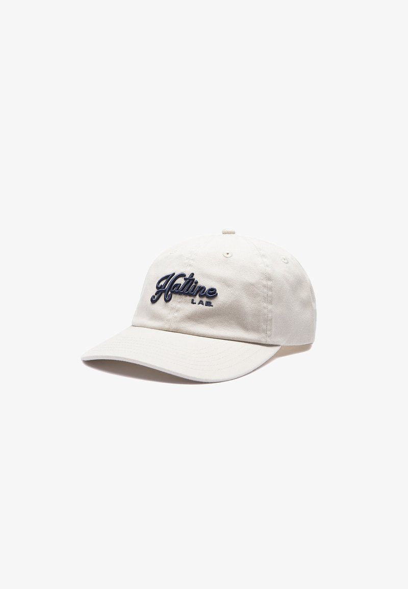Casquette de baseball beige clair avec visière incurvée et logo brodé noir "Hatline LAB." sur le panneau avant.