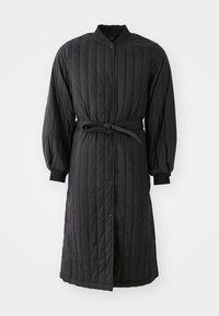 Black quilted long coat with a button front, belted waist, ribbed cuffs, and vertical stitching pattern. Soft material with a smooth texture.
