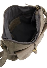 Grijze leren handtas met een zachte textuur; beschikt over een ritsluiting, gevoerde binnenkant en een enkele verstelbare schouderband. De binnenkant bevat vakken.