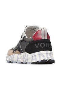 Baskets avec une tige en suède noir et textile gris, détails rouges, épaisse semelle blanche avec un logo gris, et un col rembourré.