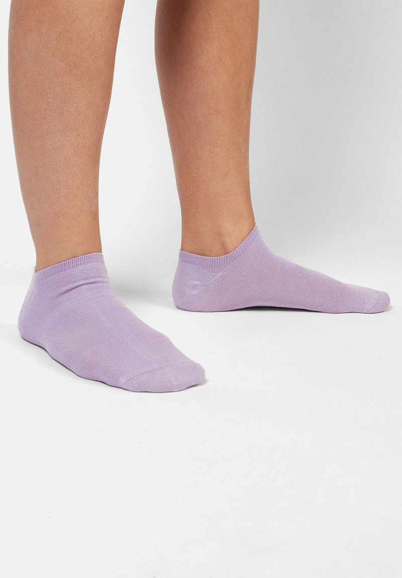 Calze alla caviglia lilla realizzate in materiale morbido. Presentano un polsino a coste e una texture liscia. Taglio sotto la caviglia, adatte per un abbigliamento informale.