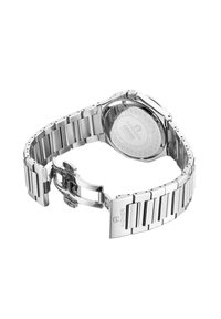 Orologio in acciaio inox argentato con bracciale a maglie, cassa rotonda e fondello trasparente che mette in mostra i meccanismi interni.