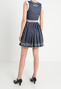 Robe en denim avec un corsage ajusté, une jupe plissée et des motifs floraux brodés au bas. Comprend une ceinture contrastante et des manches à volants.