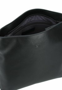 Sac en cuir noir avec une texture lisse, ouvert sur le dessus et intérieur violet. Comprend un compartiment zippé et un logo embossé sur l'extérieur.