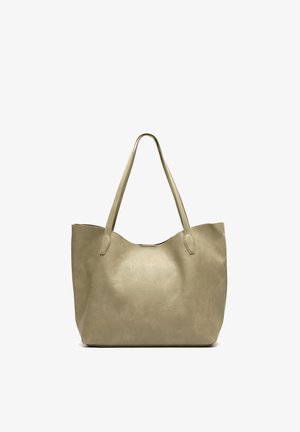 Beige leren totebag met twee lange handvatten, een gladde textuur en een licht gebogen bovenrand.