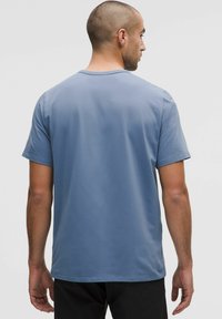 Tricou pentru bărbați cu mânecă scurtă dintr-un material moale, de culoare albastru deschis. Gât rotund, croială lejeră, textură netedă și fără modele sau grafice vizibile.