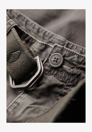 Grau gefärbter Stoffbund mit einem strukturierten dunkelgrauen Riemen, einem Metall-D-Ring und einem hellgrauen Knopf mit dem eingravierten "SUPERDRY"-Logo.