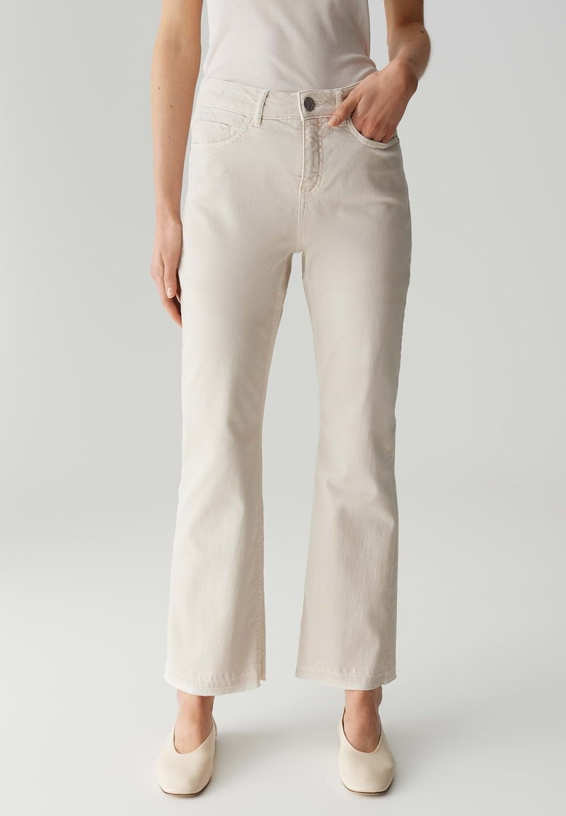 Lichtbeige flared jeans van een katoenmix. Voorzien van zijzakken, riemlussen en een knoopsluiting. Gladde textuur, casual pasvorm.