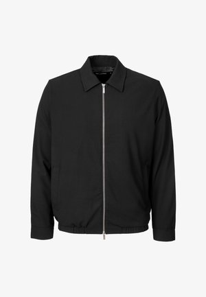 Chaqueta casual negra con mangas largas, cremallera frontal, cuello y dobladillo y puños elásticos, mostrada sobre un fondo blanco.