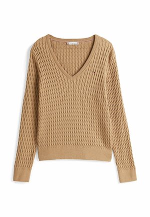 Beige, gebreide trui met een V-hals, ribgebreide zoom en lange mouwen. Heeft een geweven patroon en een klein logo op de borst.