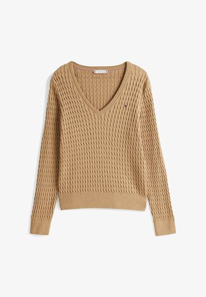 Maglione beige lavorato a maglia con scollo a V, orlo a coste e maniche lunghe. Presenta un motivo testurizzato e un piccolo logo sul petto.