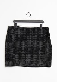 Falda con patrón en negro y gris hecha de tejido texturizado, con un acabado suave y una silueta recta, colgando de una percha negra.