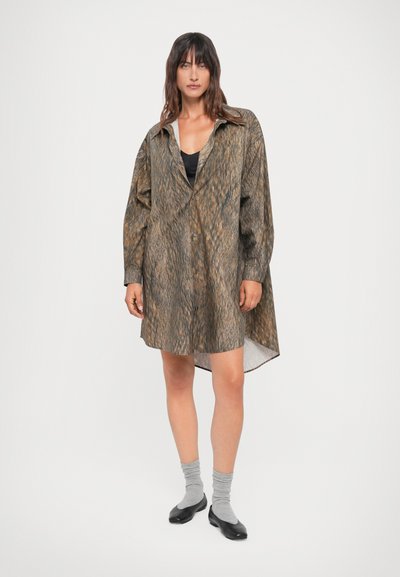 Rjava vzorčasta overshirt iz lahkega materiala, z ohlapnim krojem, zapenjanjem na gumbe, dolgimi rokavi in robom, ki je na hrbtni strani daljši.