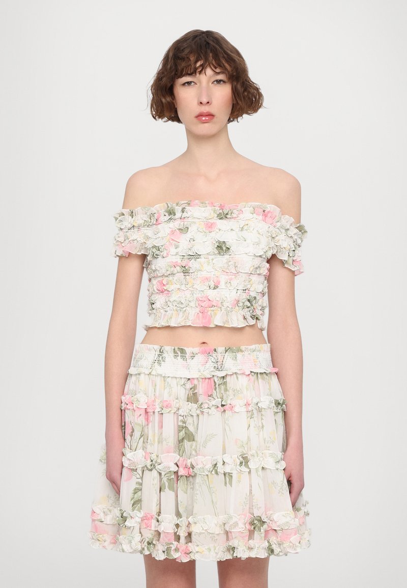 Floral off-the-shoulder crop top and matching ruffled skirt in pastel colors. Light fabric with tiered design and decorative floral accents.