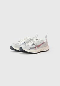 Bílé sportovní tenisky s vrškem z meshe a syntetického materiálu, reflexními prvky, gumovou podrážkou a kontrastní černou špičkou.