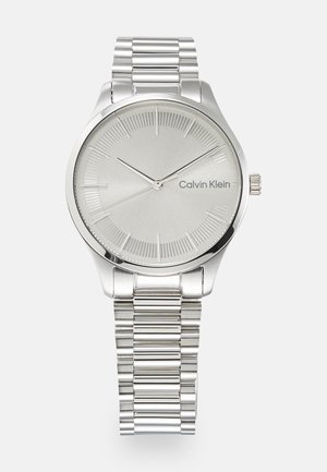 Silberne Edelstahl-Uhr mit rundem Gehäuse, minimalistischem silbernen Zifferblatt, kontrastierenden Stundenmarkierungen und einem gegliederten Metallarmband.