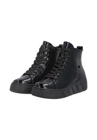 Baskets montantes noires avec un avant en cuir verni brillant, des côtés en cuir mat, des semelles épaisses à rainures et des lacets noirs sur fond blanc.