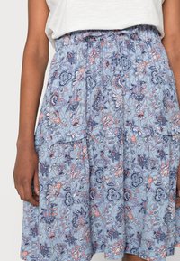 Blue floral skirt with a tiered design, featuring intricate patterns in pink and navy. Elastic waistband, lightweight fabric, and relaxed fit.