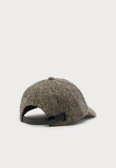 Casquette de baseball marron et grise à motif chevrons avec sangle en cuir noir réglable, vue de dos sur un fond clair.