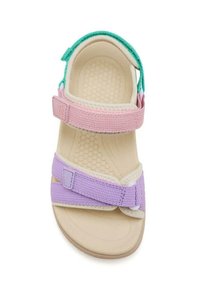 Sandalia infantil con tiras de textil en rosa y lavanda, acentos verdes, suela texturizada en beige y cierres de gancho y bucle.