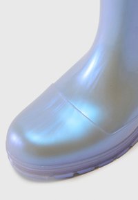 Botte de pluie bleue translucide à bout arrondi, texture lisse et finition légèrement irisée, avec une semelle en caoutchouc texturée.