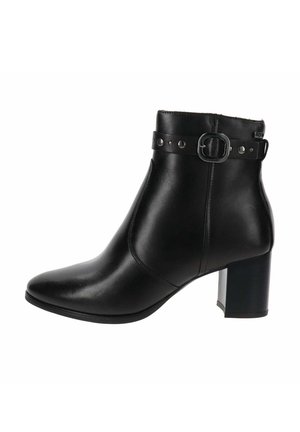 Bottine en cuir noir avec un talon carré, une sangle décorative et un détail de boucle autour du bord supérieur.