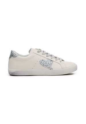 Zapatillas de piel beige con un acento de corazón de purpurina plateada texturizada y talón. Presentan cordones grises y una suela de goma gris claro.