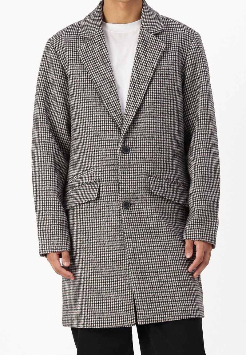 Abrigo con patrón pata de gallo en gris y negro, con cuello con solapa, dos bolsillos frontales y cierre de un solo botón. Material de mezcla de algodón.