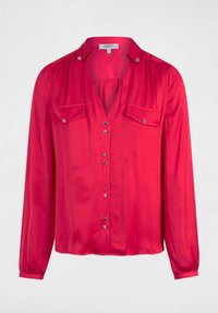 Blusa rossa di raso con maniche lunghe, due tasche sul petto e chiusura frontale con bottoni metallici. Texture morbida e vestibilità comoda.