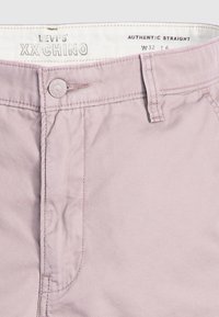 Pantaloni chino Levi's XX roz deschis, croi drept, cu închidere prin buton și buzunare laterale. Țesătură netedă cu detalii minime de cusătură.
