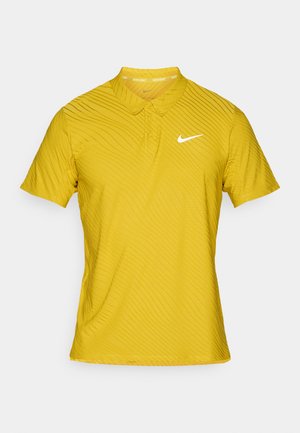Gelbes Nike-Poloshirt mit kurzen Ärmeln, Kragen und einem strukturierten Wellenmuster. Auf der linken Brust befindet sich ein weißes Nike-Logo.
