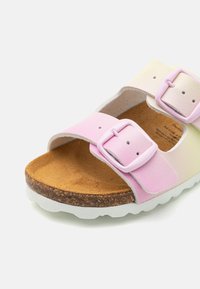 Roosa ja kreemjas kahe pandlaga sandaal, millel on korgist sisetald, valge kummist välistald ja siledad nahkrihmad.