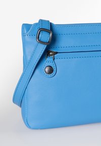 Borsa a tracolla blu in pelle con una superficie liscia, dotata di una tasca frontale con zip, tracolla regolabile e dettagli in hardware neri a contrasto.