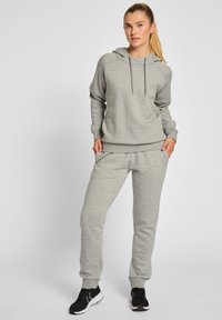 Grå bomullshuvtröja med justerbara dragband och matchande joggers. Sweatshirt har ribbat nederkant; joggers har sidofickor och avsmalnande muddar.