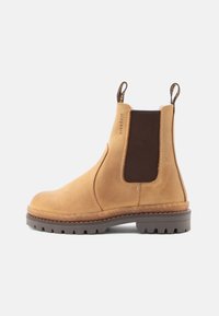 Bottines Chelsea en cuir tan avec des panneaux élastiques sur les côtés en marron foncé, bout rond, et semelle en caoutchouc robuste. Comprend des languettes à l'arrière.