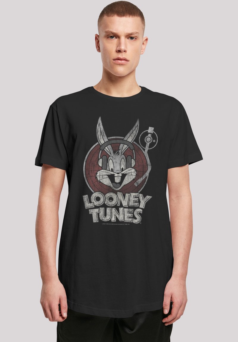 Svart bomull T-skjorte med grafikk av Bugs Bunny med hodetelefoner mot en sirkulær Looney Tunes-logo. Korte ermer, løs passform.