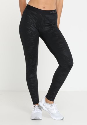 Czarne legginsy z teksturowanym wzorem w kamuflaż, wysoki stan z logo "NIKE", dopasowany krój i gładki materiał.