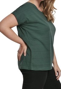 Zelené a černě pruhované tričko s krátkými rukávy, kulatým výstřihem a uvolněným střihem, vyrobené z měkké, texturované látky.