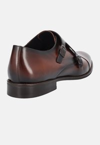 Brązowe skórzane buty eleganckie o smukłym wzornictwie, z podwójnymi klamrami i zaokrąglonym noskiem o gładkim, wypolerowanym wykończeniu.